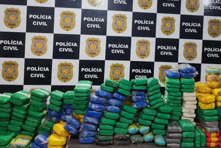 pacotes de drogas em frente ao painel da policia civil