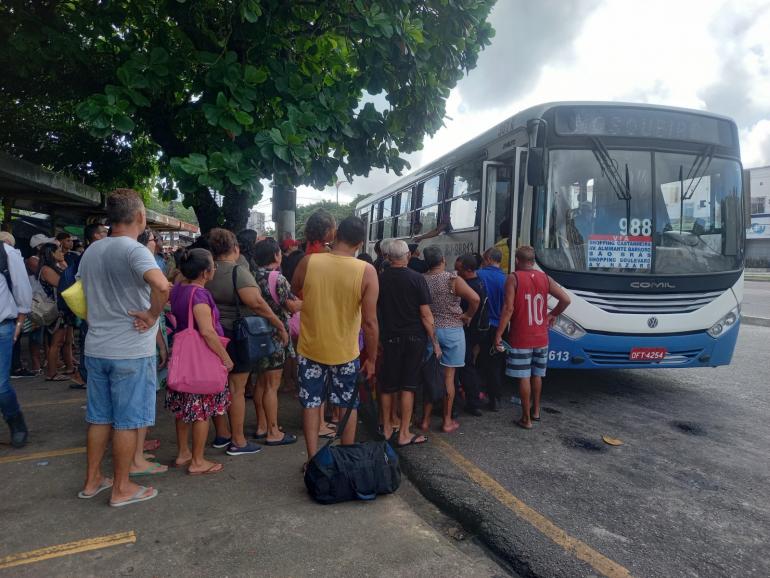 pessoas em uma fila para entrar no ônibus