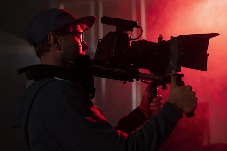 Homem filmando com camera profissional (Foto: Freepik)