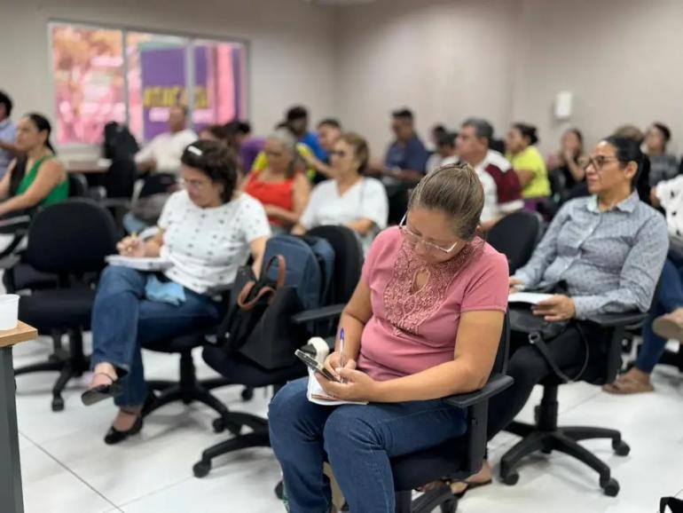 Alunos jovens e adultos estudam em sala de aula.
