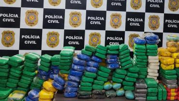 pacotes de drogas em frente ao painel da policia civil 
