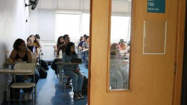 Estudantes sentados em carteiras na sala de aula
