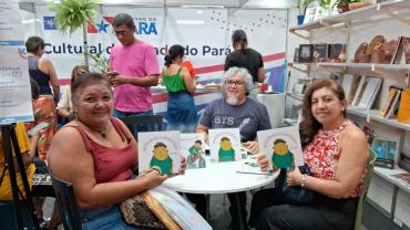 varias pessoas segurando livros na feira do livro 
