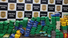 pacotes de drogas em frente ao painel da policia civil 