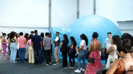 pessoas reunidas na frente do planetário móvel 