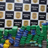 pacotes de drogas em frente ao painel da policia civil 
