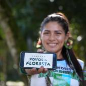 Indígena mostrando o celular com a inscrição "conexão povos da floresta"