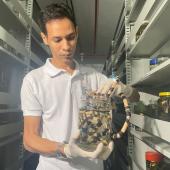 pesquisador segurando um recipiente com cobra dentro 