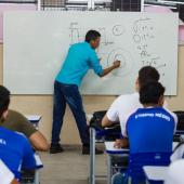 professor escrevendo no quadro e alunos observando 