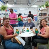 varias pessoas segurando livros na feira do livro 