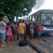 pessoas em uma fila para entrar no ônibus 
